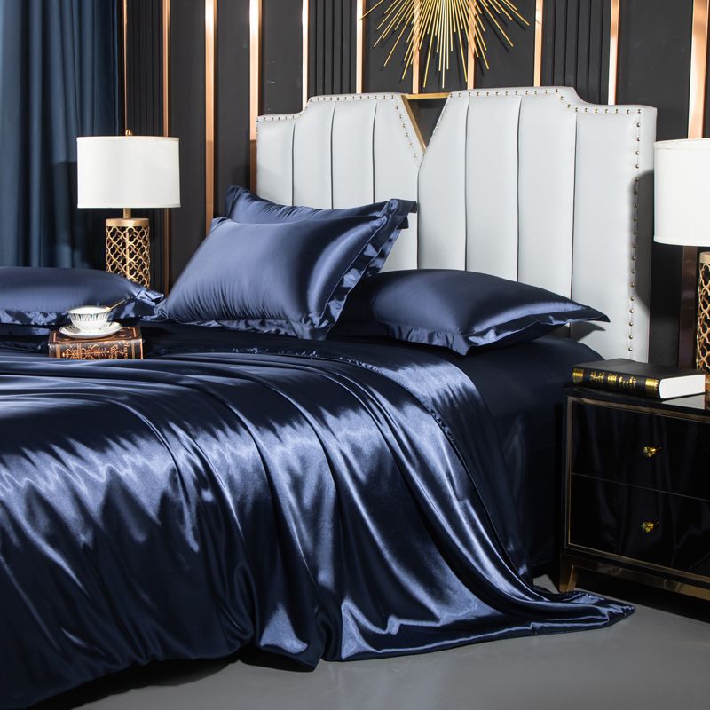 moregrowth101 Washed Silk Four-Piece Bedding Set showcasing luxurious navy silk sheets and elegant pillows on a stylish bed.