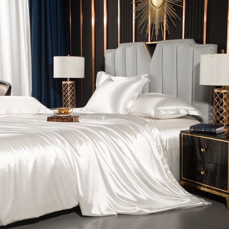 moregrowth101 Washed Silk Four-Piece Bedding Set showcasing luxurious navy silk sheets and elegant pillows on a stylish bed.
